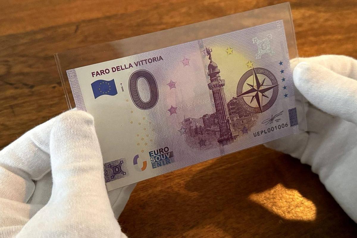 Een 0 euro-biljet in een doorzichtig hoesje, met witte handschoenen vastgehouden