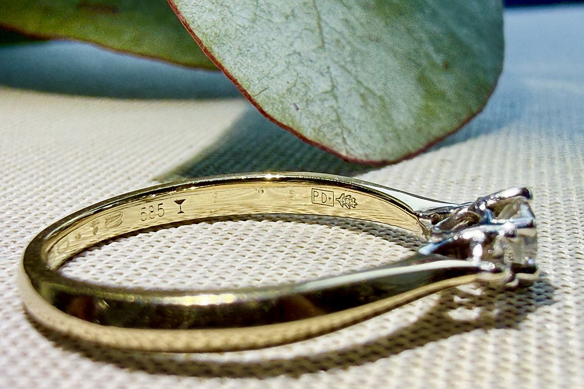 A gold engagement ring with a diamond in a white gold head
