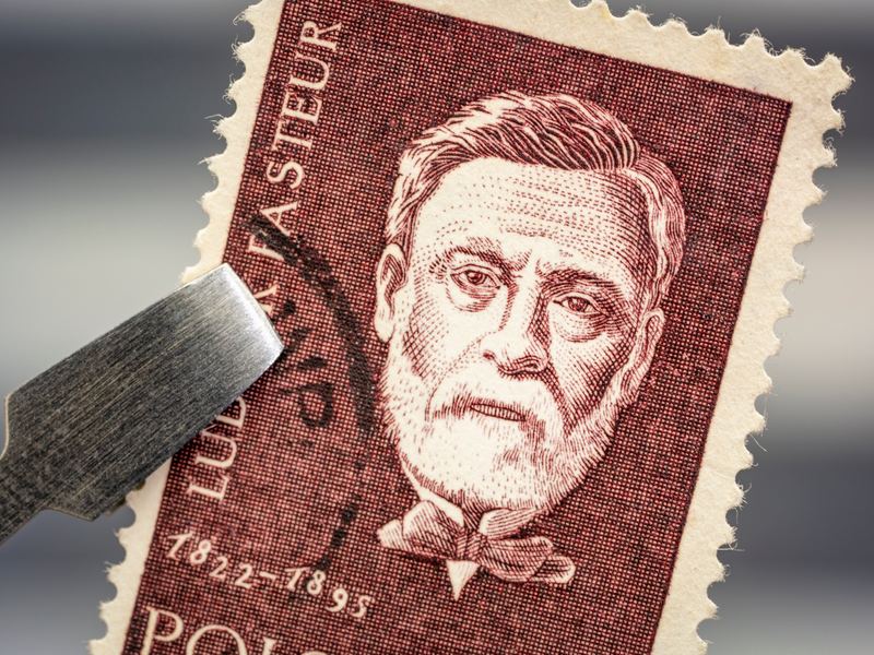 Old stamp held with tweezers