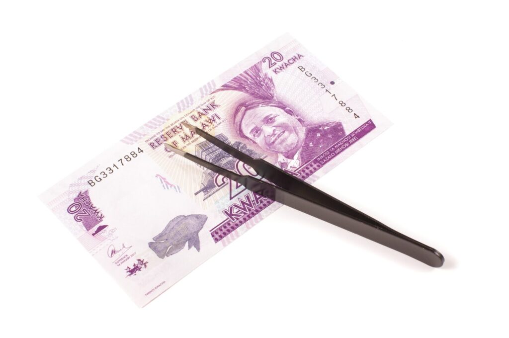 Bankbiljet met een zwart pincet op een witte ondergrond