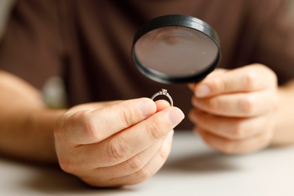 Een ring met een steen wordt door een vergrootglas bekeken